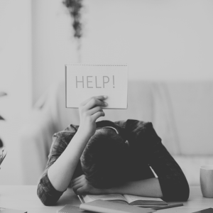 Smith Clinic Services | man leaning on counter with help sign educational support